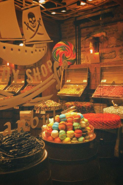 Free Colorful macarons and sweets displayed in a cozy candy shop setting. Stock Photo