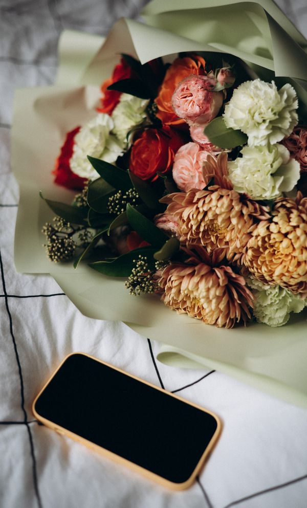 Spring bridal bouquet flat-lay with a phone, mid-Instagram-post