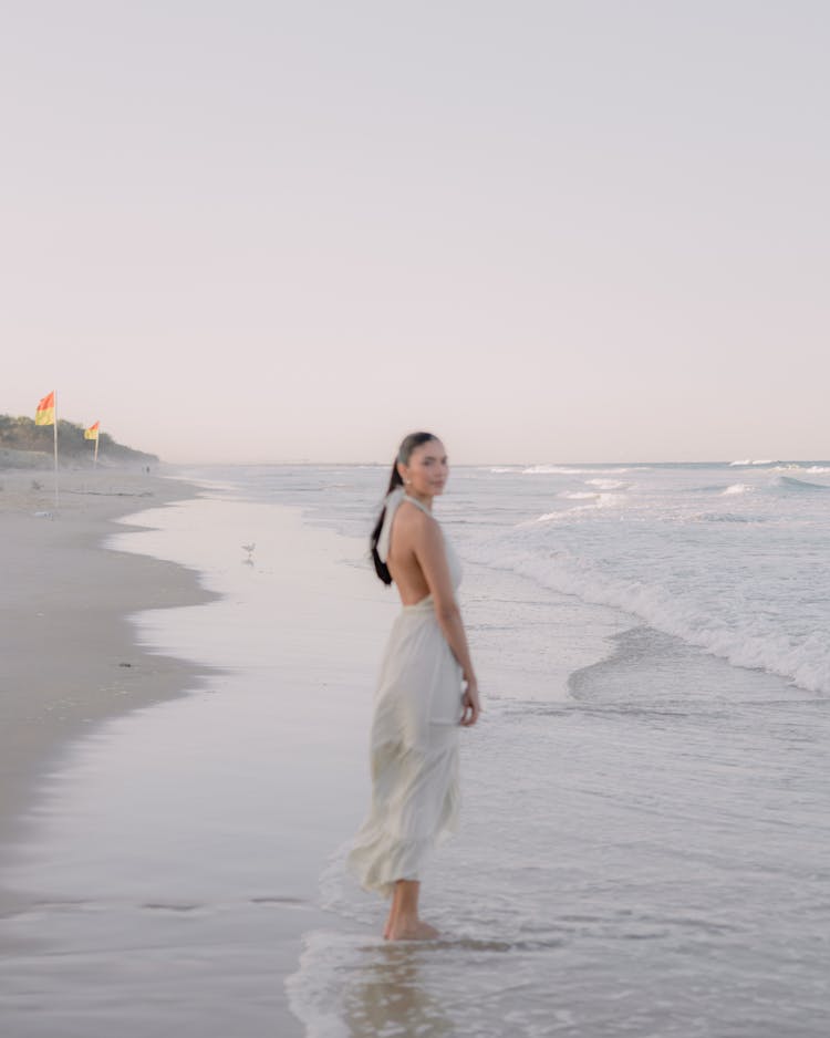 Woman Standing Barefoot At Beach