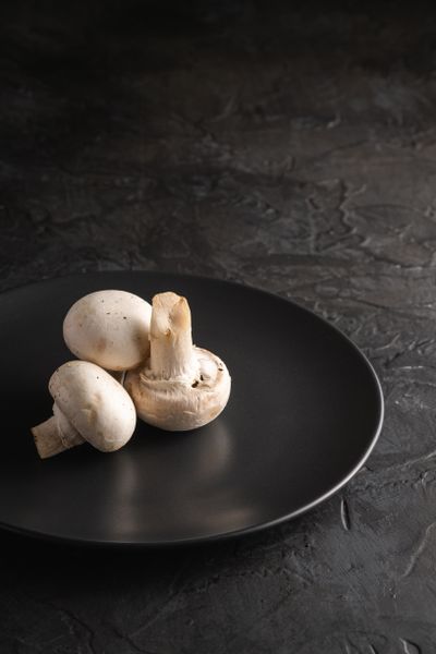 White mushrooms on a black plate, photo by Rodion Kutsaiev on Pexels