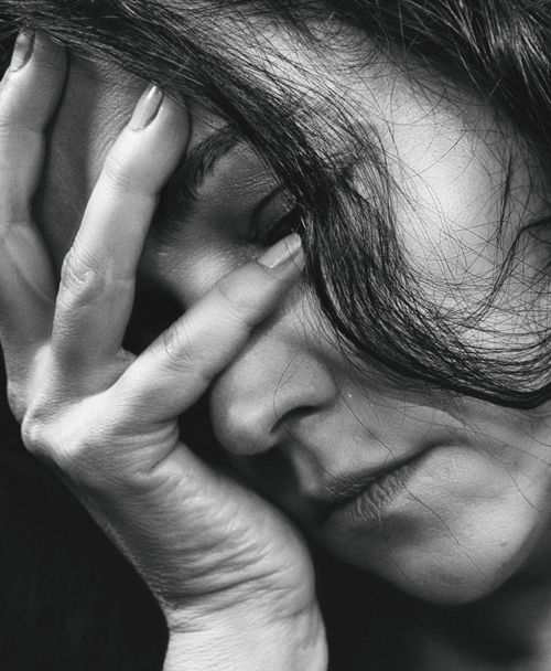 Free Close-up black and white portrait of a woman expressing emotion with her hand on her face. Stock Photo