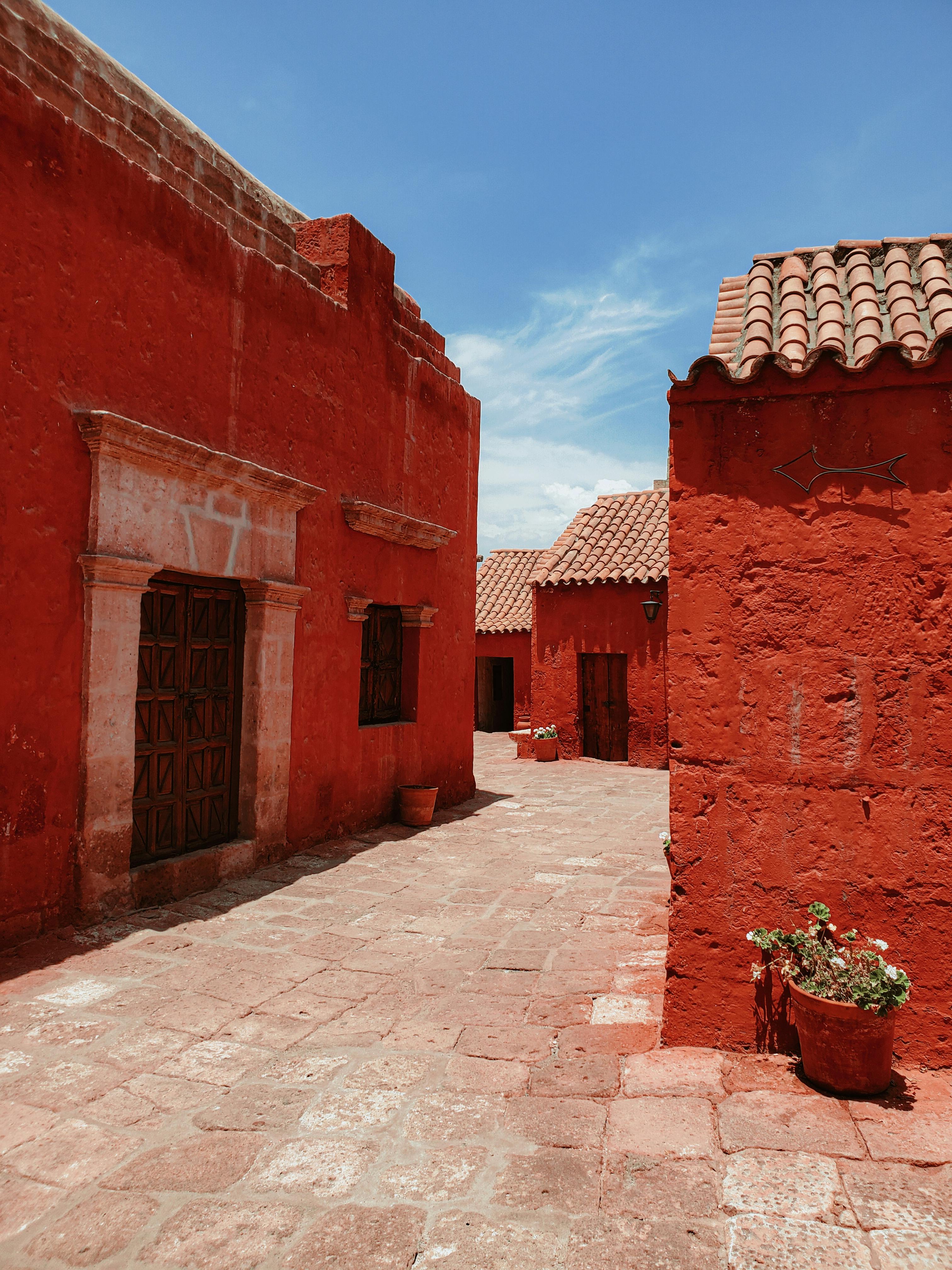 A vibrant red street showcasing traditional architecture and blue sky.
