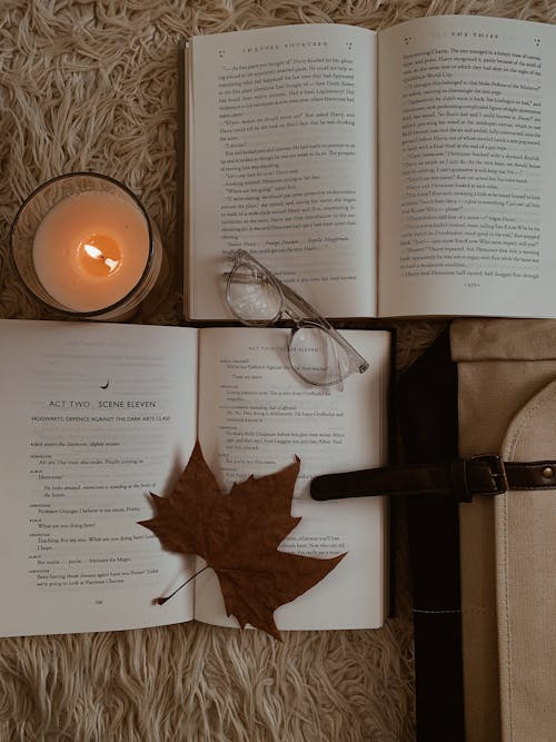Wax Candle, Maple Leaf and Eyeglasses on Books