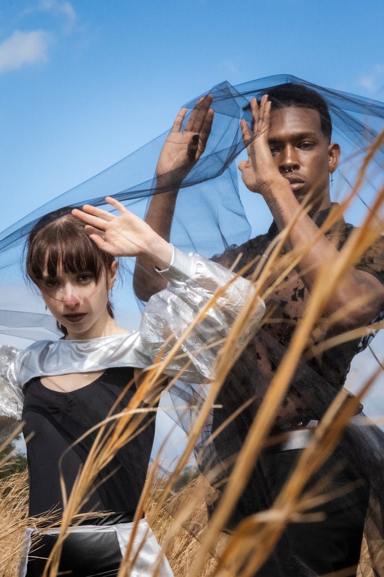 Man And Woman Under Black Veil In Field