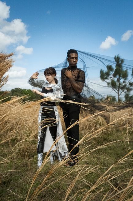 Artistic fashion shoot with models in a rural Kissimmee field with tall grass.