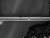 一张黑白鸟瞰图展示了汽车穿过水上桥梁及周围树木的景象