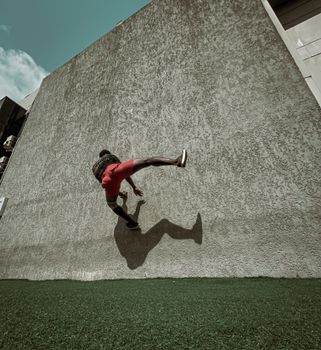 Captivating shot of a man performing parkour against a wall in Lagos, showcasing urban movement and athleticism.