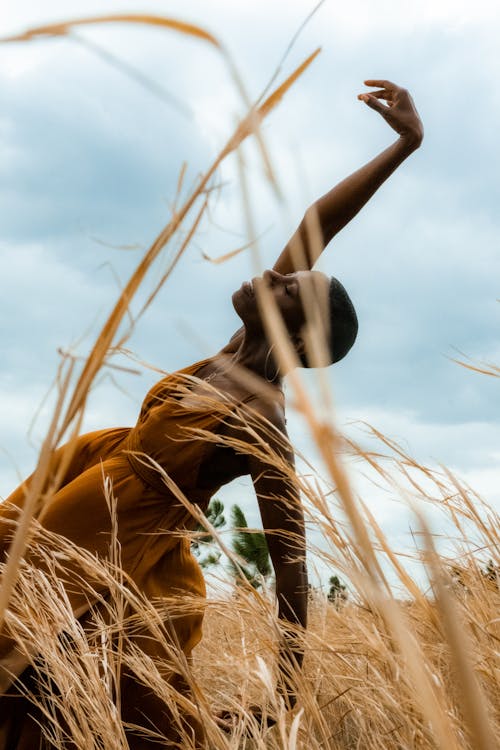 African Woman Posing Among Grass on a Field 