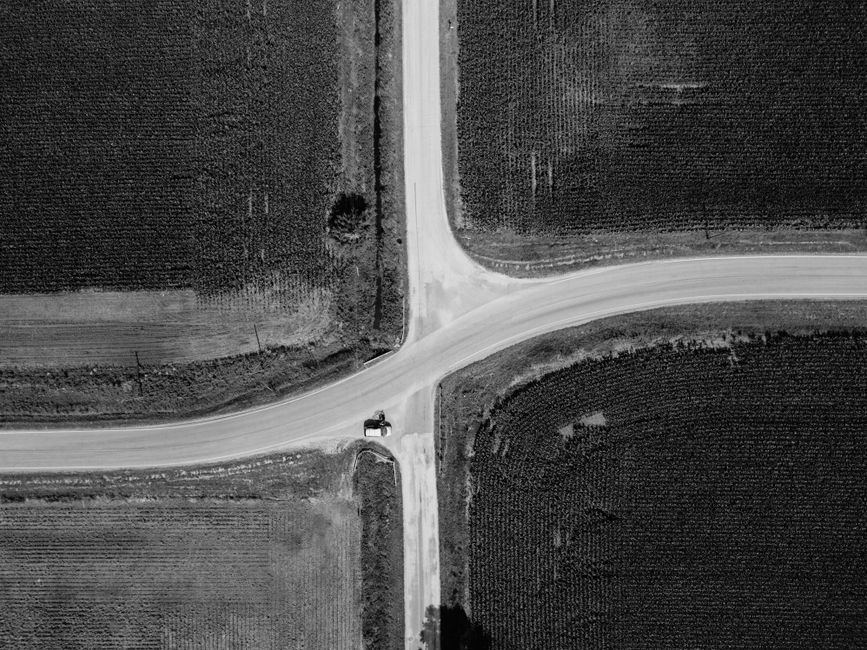 Aerial black and white photo of a rural intersection surrounded by farmlands.