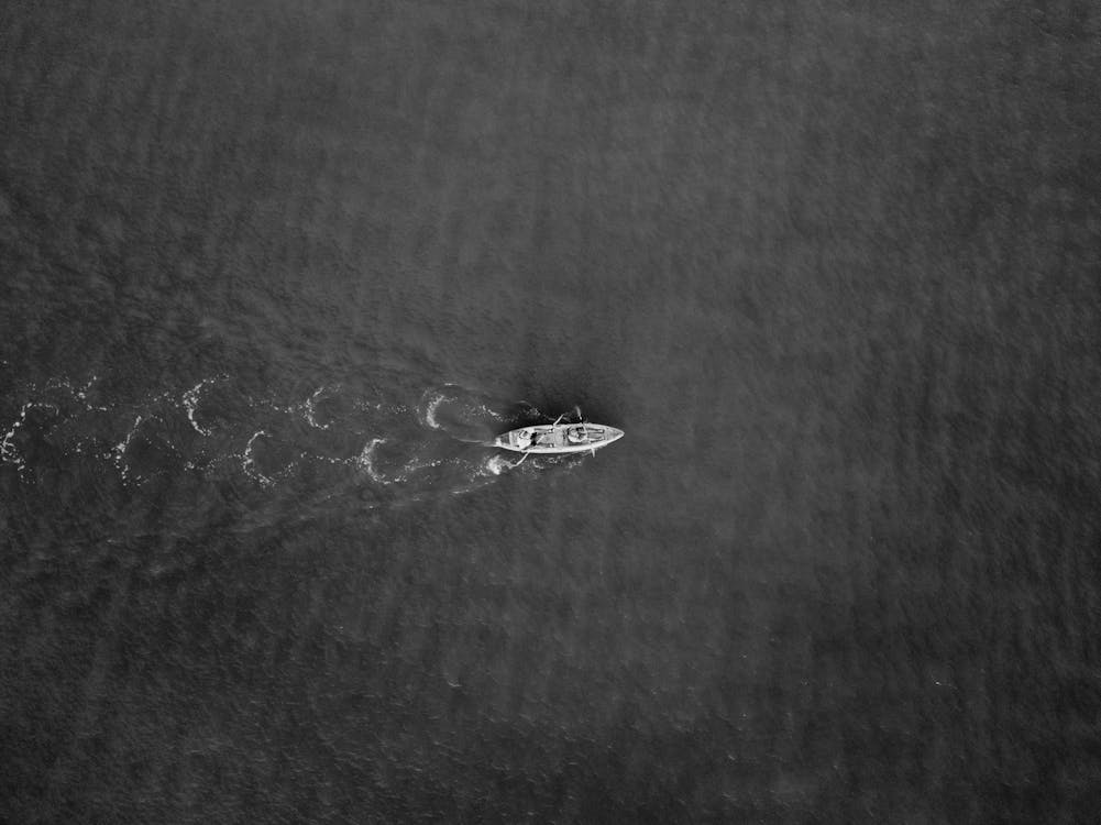 Grayscale Photo of Boat on Water