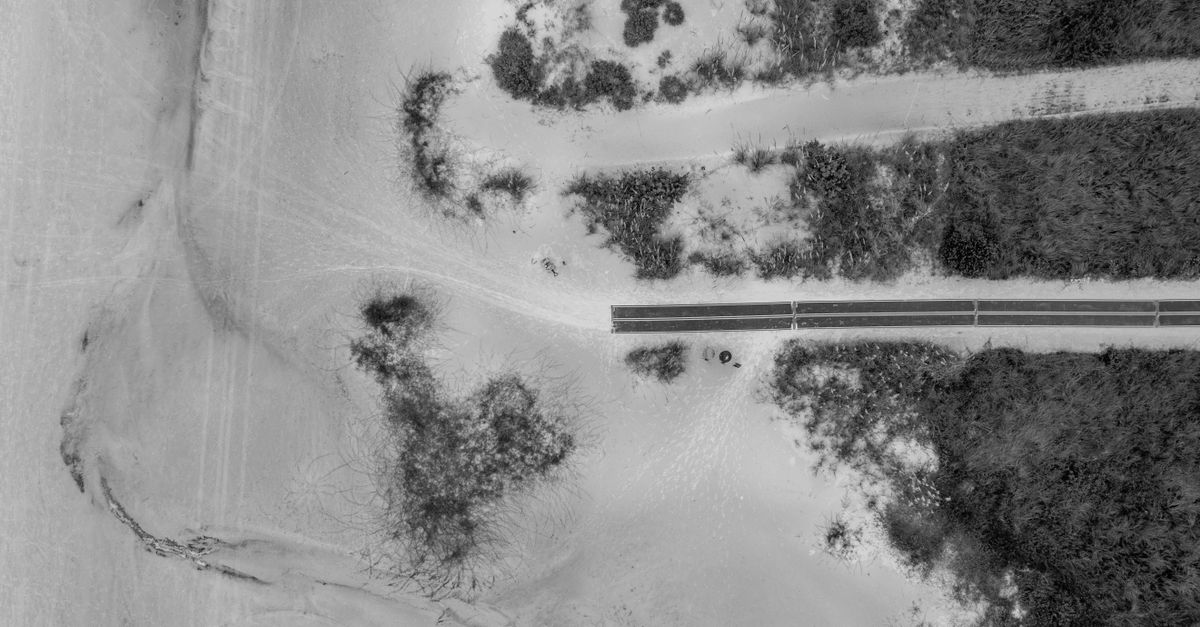 Aerial view of Fort Myers Beach showcasing sandy dunes and a roadway intersecting the landscape.