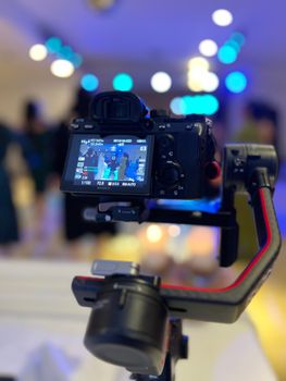 Close-up of a professional camera mounted on a gimbal, capturing a vibrant setting.
