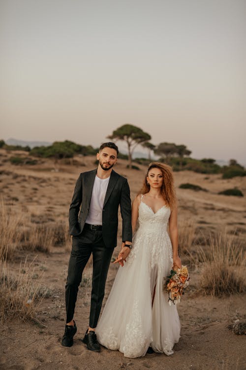 Newlyweds Standing Together on Grassland