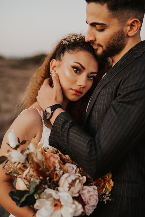 Hugging Newlyweds with Flowers Bouquet