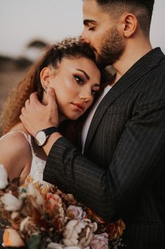 A tender moment between a bride and groom, showcasing love and intimacy with a bouquet.