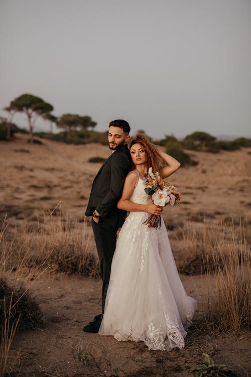 Newlyweds Standing on Grassland