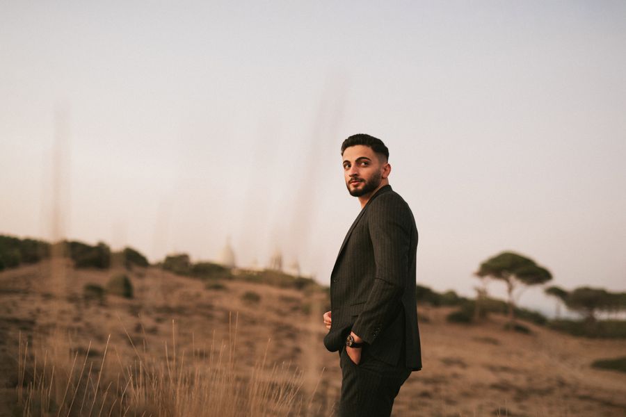 Man in a suit on open hillside at dusk, photo by casper somia on Pexels
