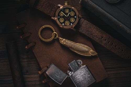 Free Flat lay of rustic leather accessories with a wristwatch, lighter, and keychain. Stock Photo