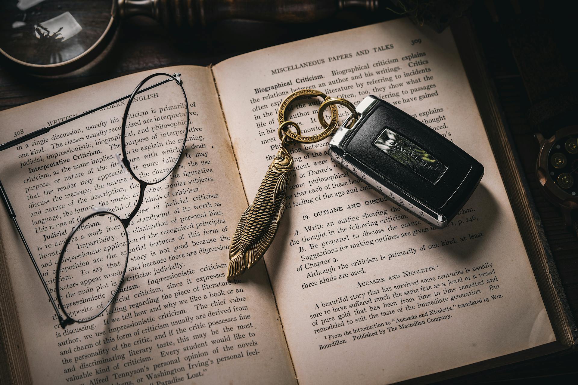 Jaguar Key Fob with Brass Fish-shaped Box Cutter and Eyeglasses on an Open Book