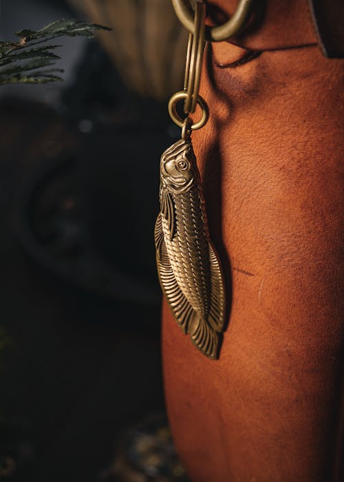 Brass Fish-shaped Pendant Attached to a Brown Leather Bag