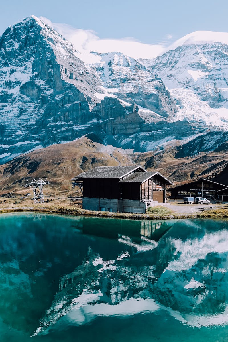 Brown Wooden House and Mountain Reflecting on Lake