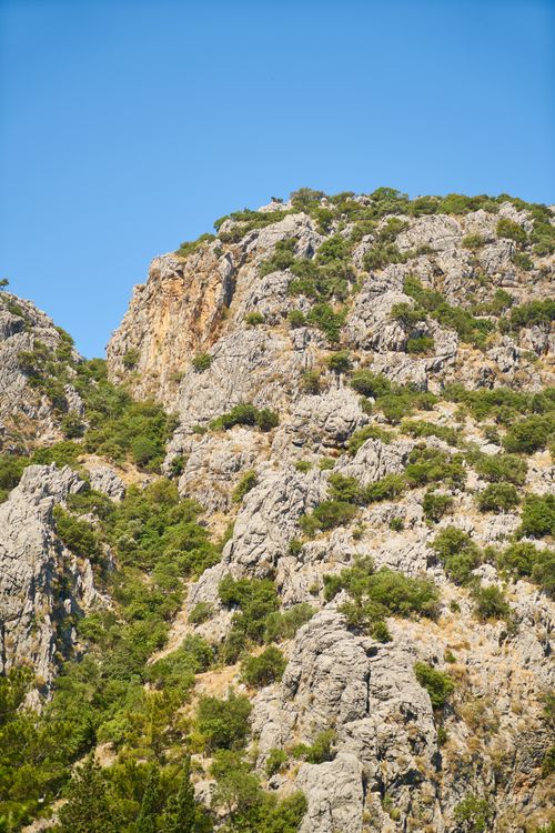 Free A stunning view of a rocky mountain under a clear blue sky, capturing nature's beauty and rugged terrain. Stock Photo