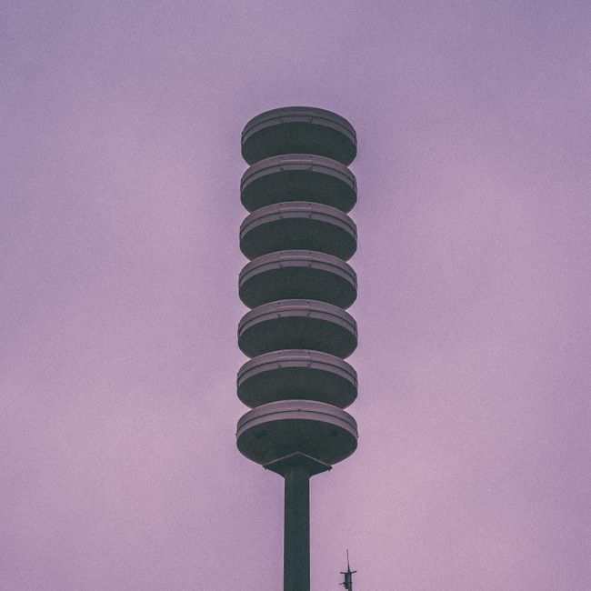 Minimalist shot of a contemporary communication tower silhouetted against a purple evening sky. Minimalist shot of a contemporary communication tower silhouetted against a purple evening sky.