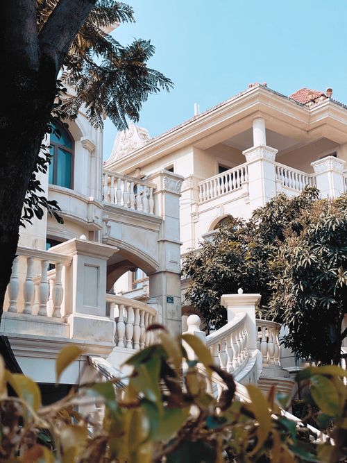 Free A stunning mansion featuring classical architecture with lush foliage and a clear sky. Stock Photo