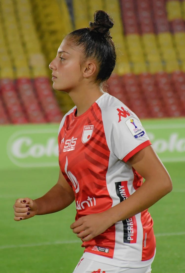 Woman In Uniform Playing Football On Field