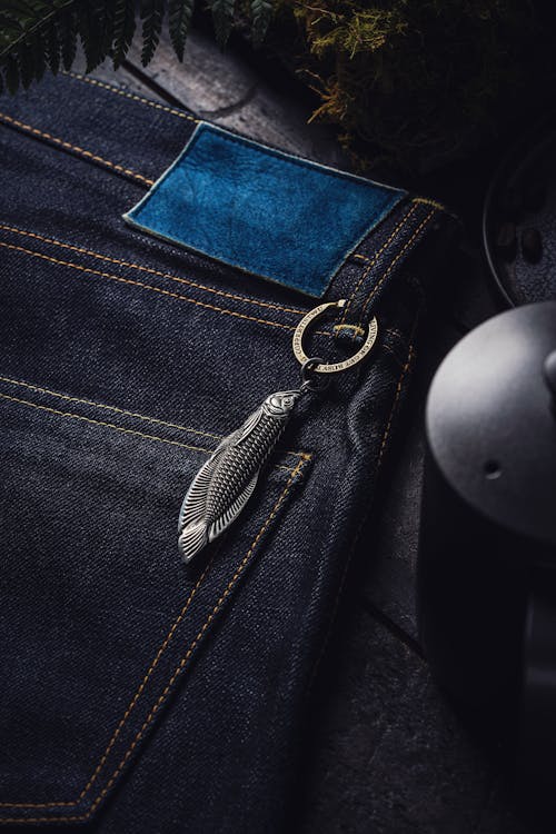 Steel Keychain and Box Opener in the Shape of a Arowana Fish Attached to the Belt Loop of Jeans