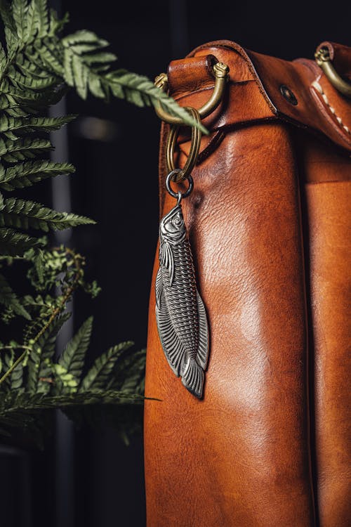 Steel Pendant in the Shape of a Fish Attached to a Brown Leather Bag