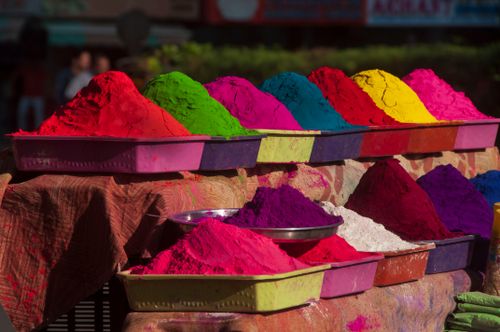 Free Colorful Holi powder stacks on display at a sunlit street market in Ahmedabad, India. Stock Photo