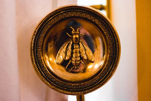 Free Close-up of a decorative golden plate with an embossed insect design, adding elegance. Stock Photo