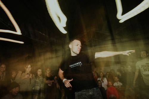 Free A dynamic scene of a dancer performing at a lively night party with a crowd gathered around. Stock Photo