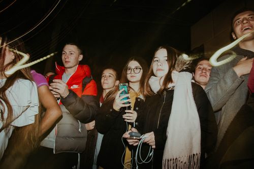 Free A lively group of young adults enjoying a night out, capturing the energy and excitement of an evening party. Stock Photo