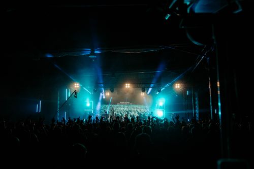 Free Energetic crowd enjoying live music at a night concert with dazzling stage lights. Stock Photo