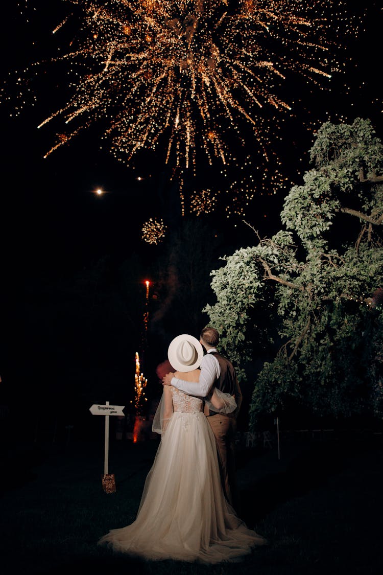 Bride And Groom Watching Fireworks In Night Park