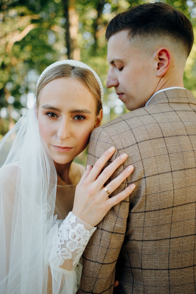 Woman In Wedding Dress Hugging Man In Suit