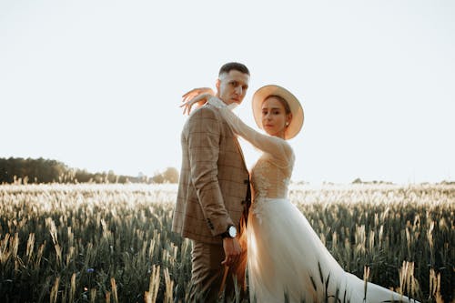 Newlyweds Posing and Hugging on Field