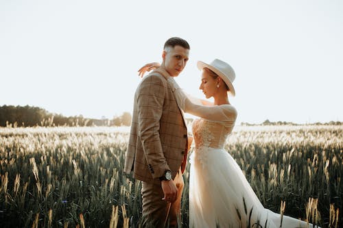 Man and Woman in Wedding Suit Posing on Field