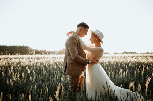 Sunlight over Newlyweds Hugging on Field