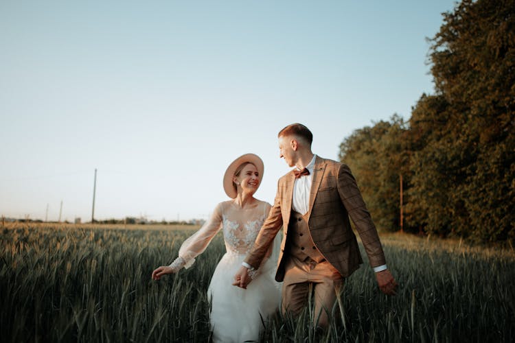 Newlywed Couple Walking In Field