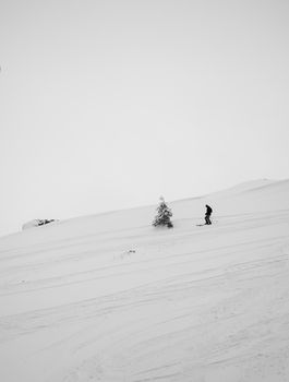 Skier descends snowy slope in Kolasin, Montenegro during winter.