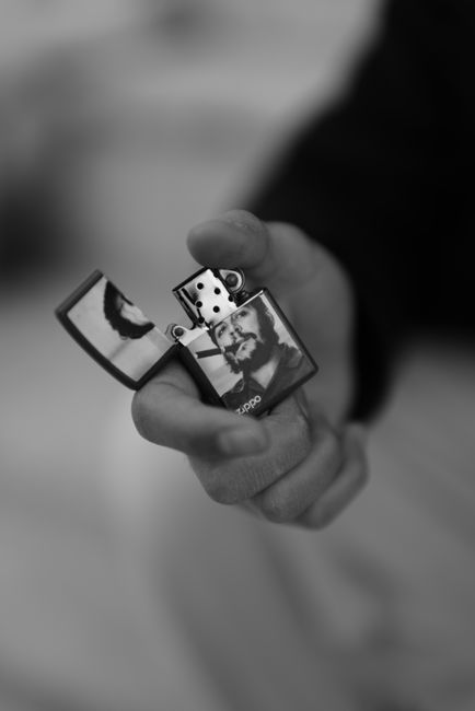 A detailed black and white image of a hand holding a lighter with a portrait, Erbil, Iraq.