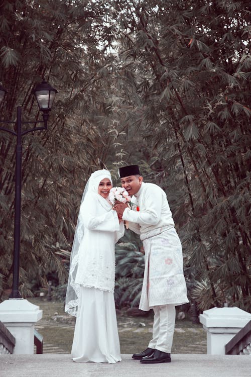 Woman and Man Posing in Traditional Wedding Clothing