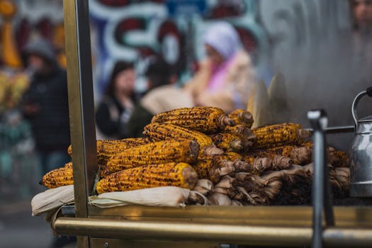 Close-up of grilled corn at a street food stand, creating a vibrant urban food scene.