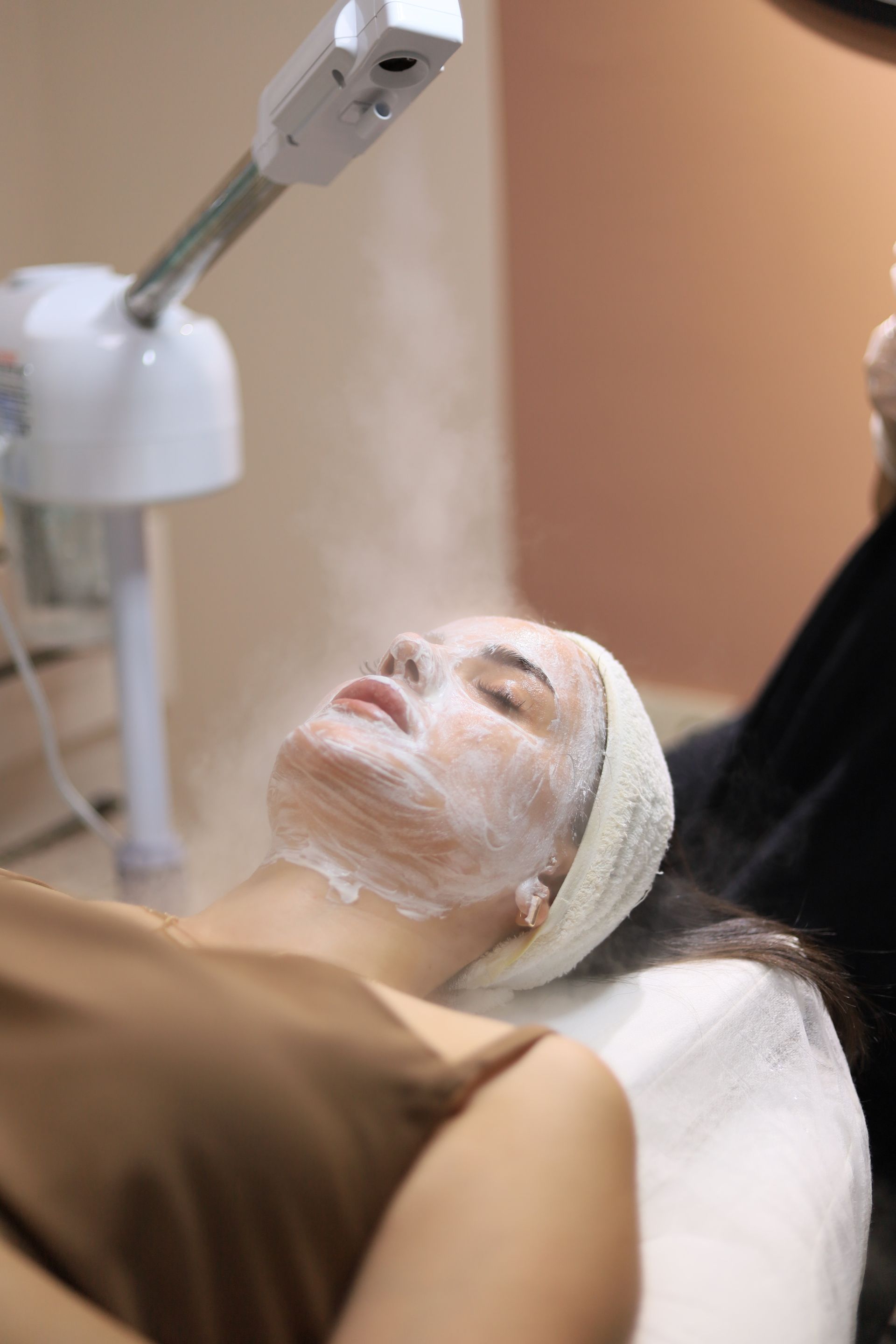 Woman receiving a calming facial treatment in a serene clinic