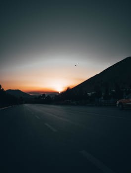 Serene sunset view over a mountain road, perfect for travel inspiration.