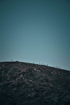 暮色中，一群轮廓鲜明的徒步旅行者正在攀登岩石山脊