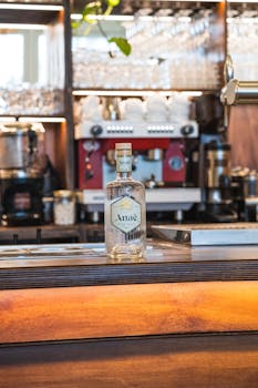 A stylish Anae gin bottle on a polished bar counter with a vibrant modern cafe backdrop.